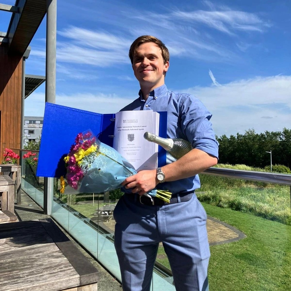 Dr. Yaniv Proselkov holding his Cambridge PhD thesis binder